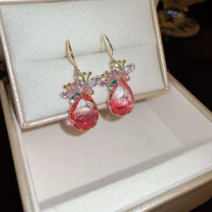 Macro view of elegant zircon flower earrings with pink teardrop crystals in jewelry box