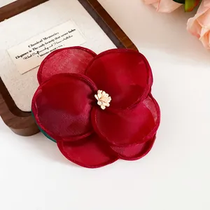 Nahaufnahme der dunkelroten Stoff-Kamelien-Haarspange mit Organza-Blüten
