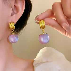 Elegant irregular resin drop earrings with golden accents and purple sphere pendant.