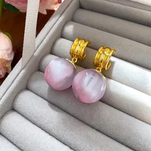 Elegant minimalist resin ball pendant earrings with irregular gold-tone geometric design