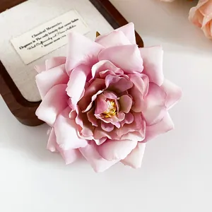 Detaillierte Nahaufnahme einer rosa Stoffblumen-Haarspange mit realistischen Blütenblättern