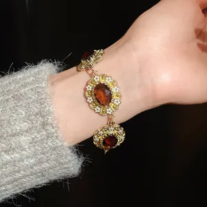 Detailed view of vintage gold floral bracelet with amber resin stones on wrist