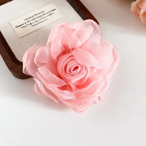 Nahaufnahme einer eleganten rosa Stoffrose-Haarspange mit weichen Chiffonblättern