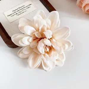 Nahaufnahme einer cremefarbenen Stoffblumen-Haarklammer mit realistischen Blütenblättern.
