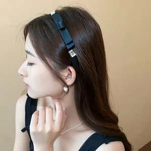 Elegante cerchietto in raso nero retrò francese con strass mostrato su una modella