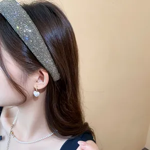 Primo piano di cerchietto con strass e orecchini di perle a cuore su una modella