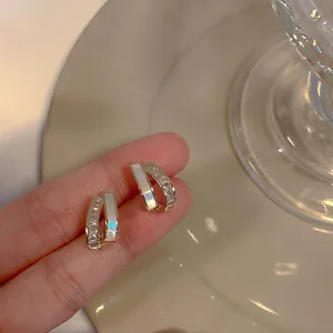 Close-up of retro baroque gold-tone earrings with elegant shell inlay and sparkling cubic zirconia