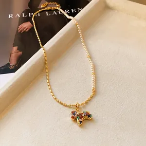 Détail du collier avec pendentif cheval en zircon, chaîne de perles et billes dorées