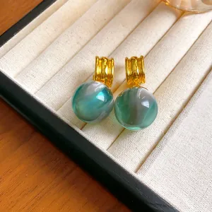 Detailed macro view of elegant green marbled resin sphere drop earrings with gold plating