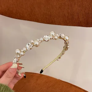 Gros plan d'un serre-tête baroque français avec perles et strass sur monture dorée.