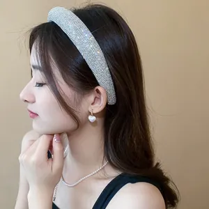 Modella elegante con cerchietto imbottito in strass argento e orecchini di perle.