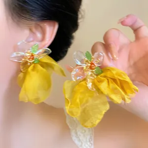 Close-up detail of elegant yellow chiffon flower tassel earrings with delicate beadwork.