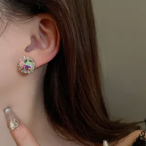 Elegant iridescent round stud earrings with sparkling zircon halo on model's ear