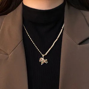 Détail du collier plaqué or avec pendentif cheval en zircon et perles nacrées