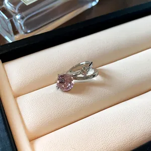 Primo piano di un elegante clip per orecchie con cristallo rosa tondo e piccoli diamanti