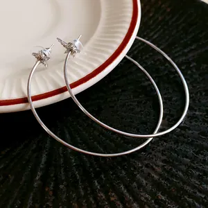 Detailed macro view of minimalist silver star hoop earrings with clear zircon stones