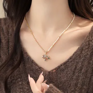 Détail rapproché d'un collier de perles et d'or orné d'un pendentif poney en zircon