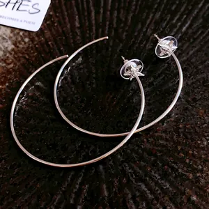 Detailed macro view of elegant silver hoop earrings with zircon star stud accents