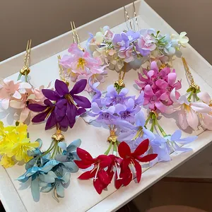 Close-up detail view of various colorful fabric flower hairpins on a beige tray