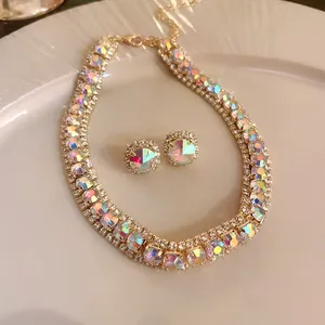 Detailed view of gold-tone necklace and earring set with iridescent crystals.