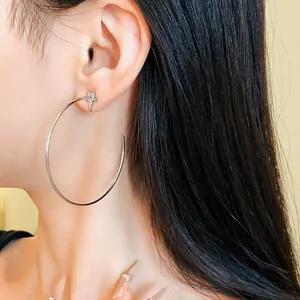 Detailed close-up showing silver needle hoop earring with zircon star stud on model's ear