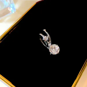 Vista dettagliata di un ear cuff in argento con due pietre rotonde scintillanti su velluto.