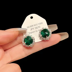 Detailed view of elegant emerald green round halo stud earrings with silver plating