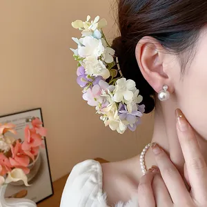 Close-up of elegant Korean style fabric flower hair pin worn on model's bun hair