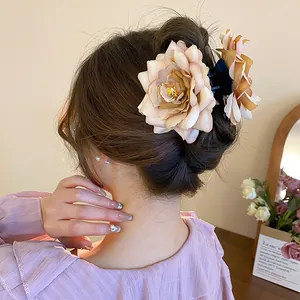 Élégante pince à cheveux en forme de rose en tissu pour un chignon sophistiqué à l'arrière.