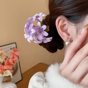 Detailed view of a elegant purple fabric flower hairpin styled in a soft hair bun