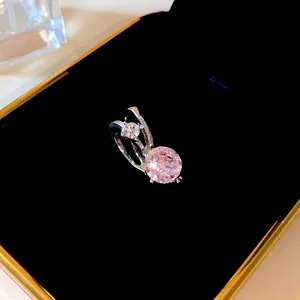 Dettaglio di un earcuff in argento minimalista con gemme rotonde rosa e bianche