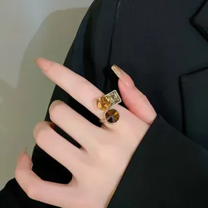 Close-up detail of a gold-plated open ring featuring chocolate zircon geometric stones.