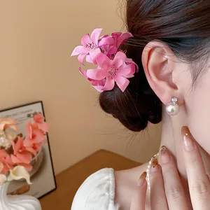 Detail of sweet pink fabric flower hair pin worn in a sophisticated bun hairstyle.
