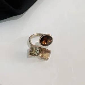 Detailed view of faceted champagne and chocolate zircon stones on gold plated open ring