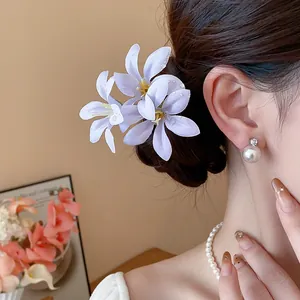 Close-up of a purple cloth flower hairpin in a bun, showcasing elegant texture and design