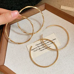 Detailed view of gold hoop earrings with twisted and smooth finishes