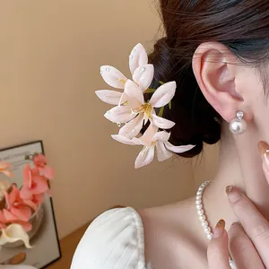 Detailed close-up view of a pink fabric flower hair fork worn by an elegant Asian woman