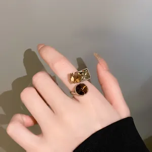 Close-up view of gold-plated index finger ring with amber cubic zirconia stones