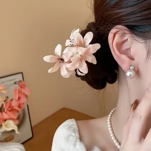 Close-up detail of sweet pink fabric flower hair pin on an elegant hairstyle bun