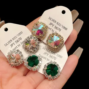 Close-up detail of vintage zircon stud earrings in various colors on white display cards.