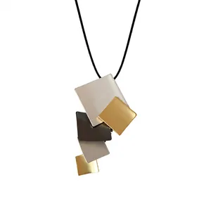 Geometric metal plate necklace featuring multi-colored overlapping rectangles on a black cord.