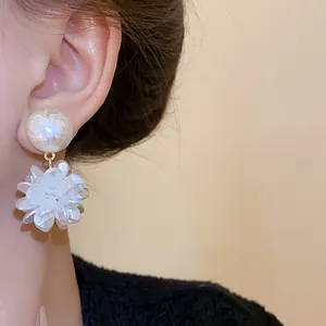 Detailansicht eleganter Ohrring mit weißer Blume und runder Perle am Model getragen