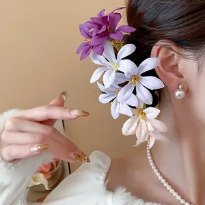 Detailed view of elegant fabric flower hairpins with realistic water droplets on model