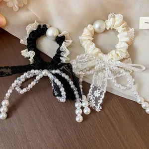 Detail view of French style lace bow hair scrunchies with elegant white pearl accents