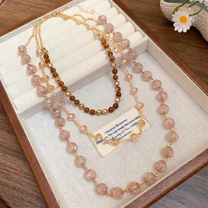 Elegante collana a tre strati di perle di cristallo rosa con catena dorata da donna