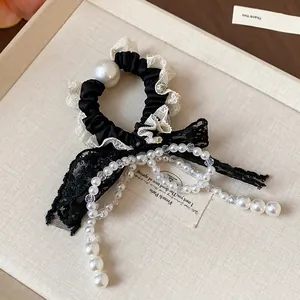 Close-up of elegant French lace bow hair tie with pearl bead tassels for women