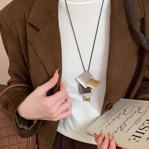 Close-up of geometric layered metal square pendant necklace on model
