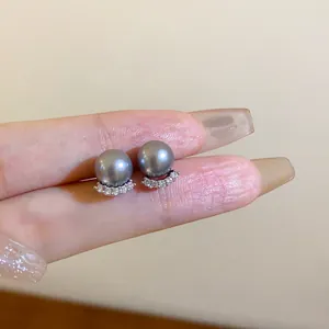 Detailansicht der grauen Perlenohrstecker mit diamantbesetzter, gebogener Basis