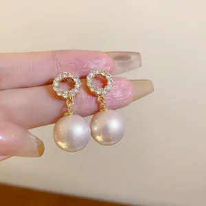 Detailansicht eleganter Silbernadel-Ohrringe mit glänzenden Strasssteinen und rosa Perlen