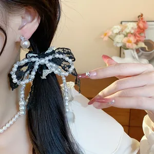 Elegant black lace bow hair tie with pearls detail for a sophisticated French hairstyle